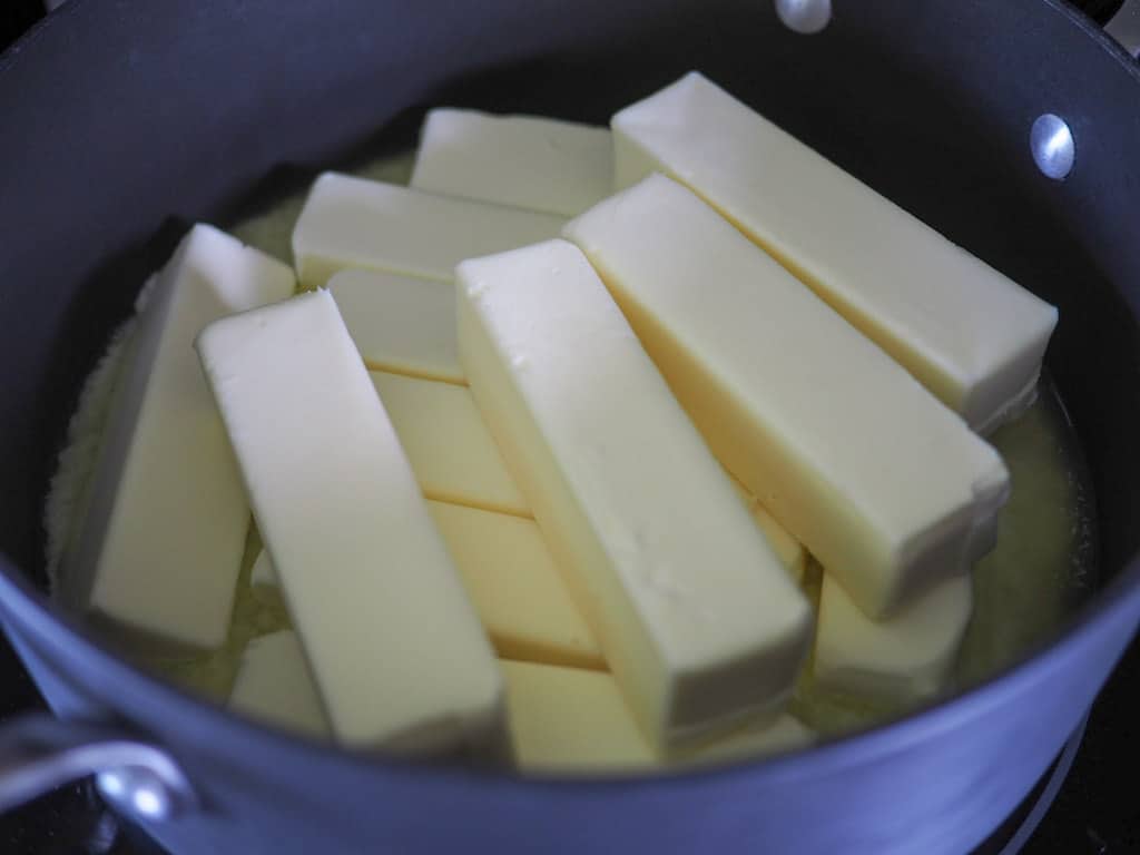 A large black saucepan filled with 12 sticks of butter.