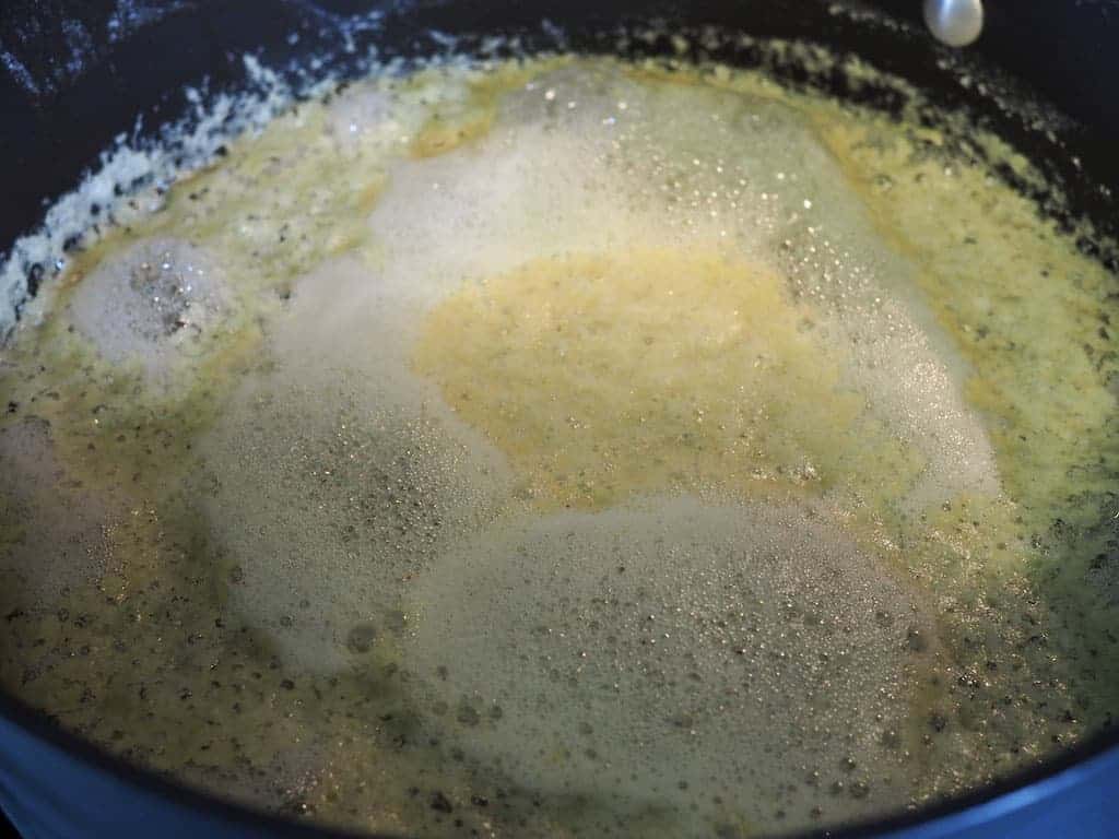 A large black saucepan filled with bubbling melted butter.