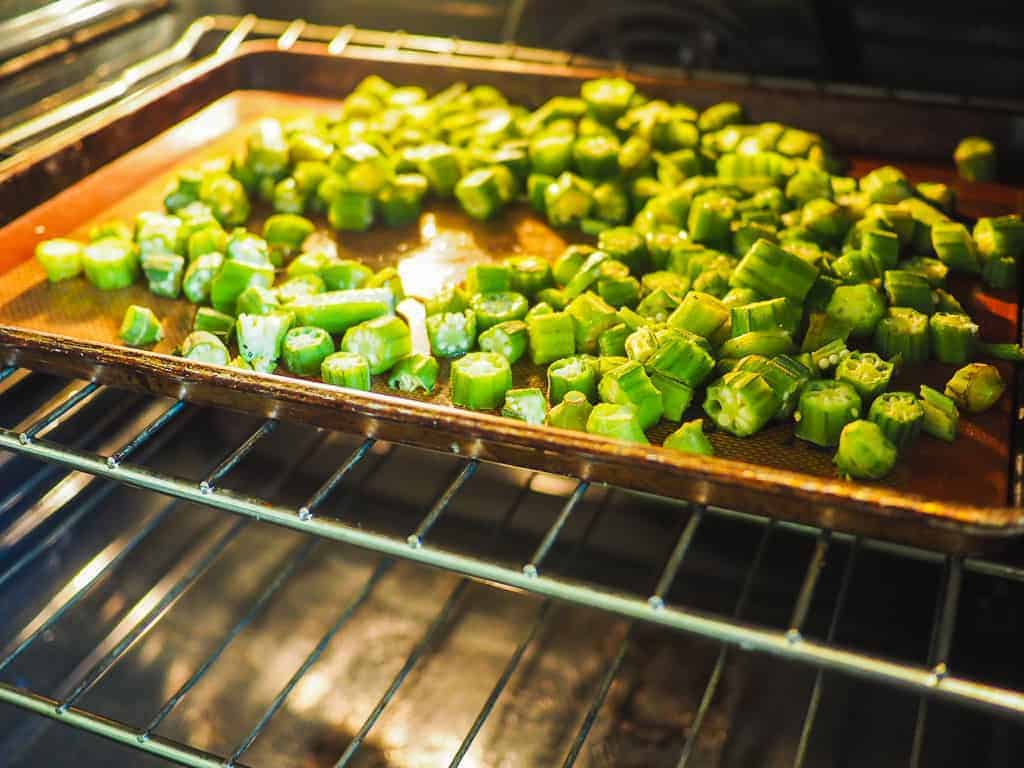 A non-stick baking sheet with cut okra.