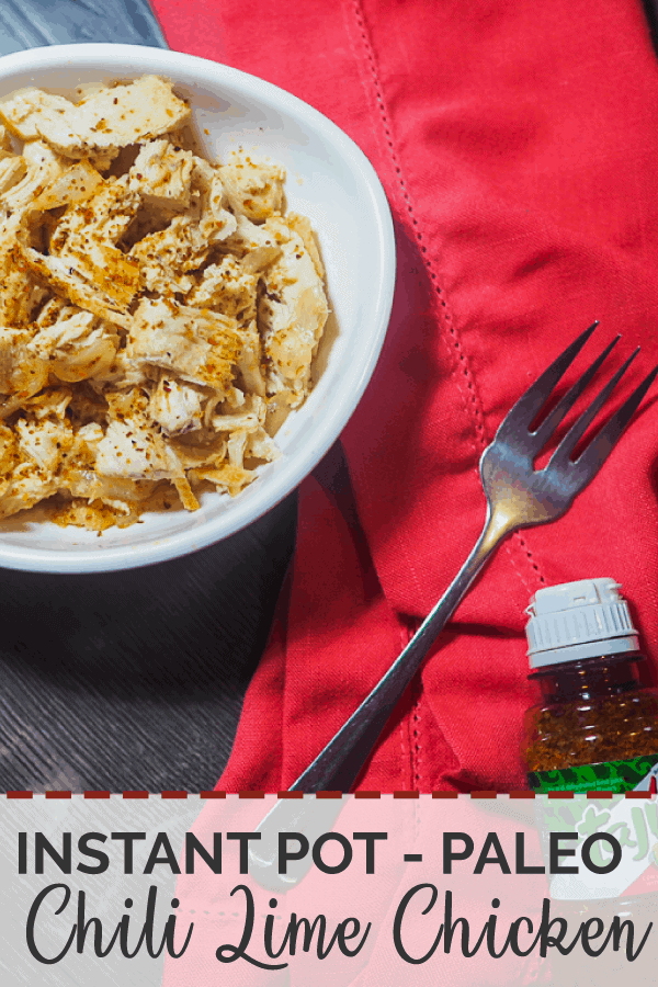 A bowl of instant pot paleo chili lime chicken with a red napkin, a bottle of Tajin seasioning, and a fork.