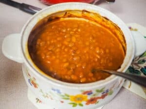 A small crock pot filled with baked beans.