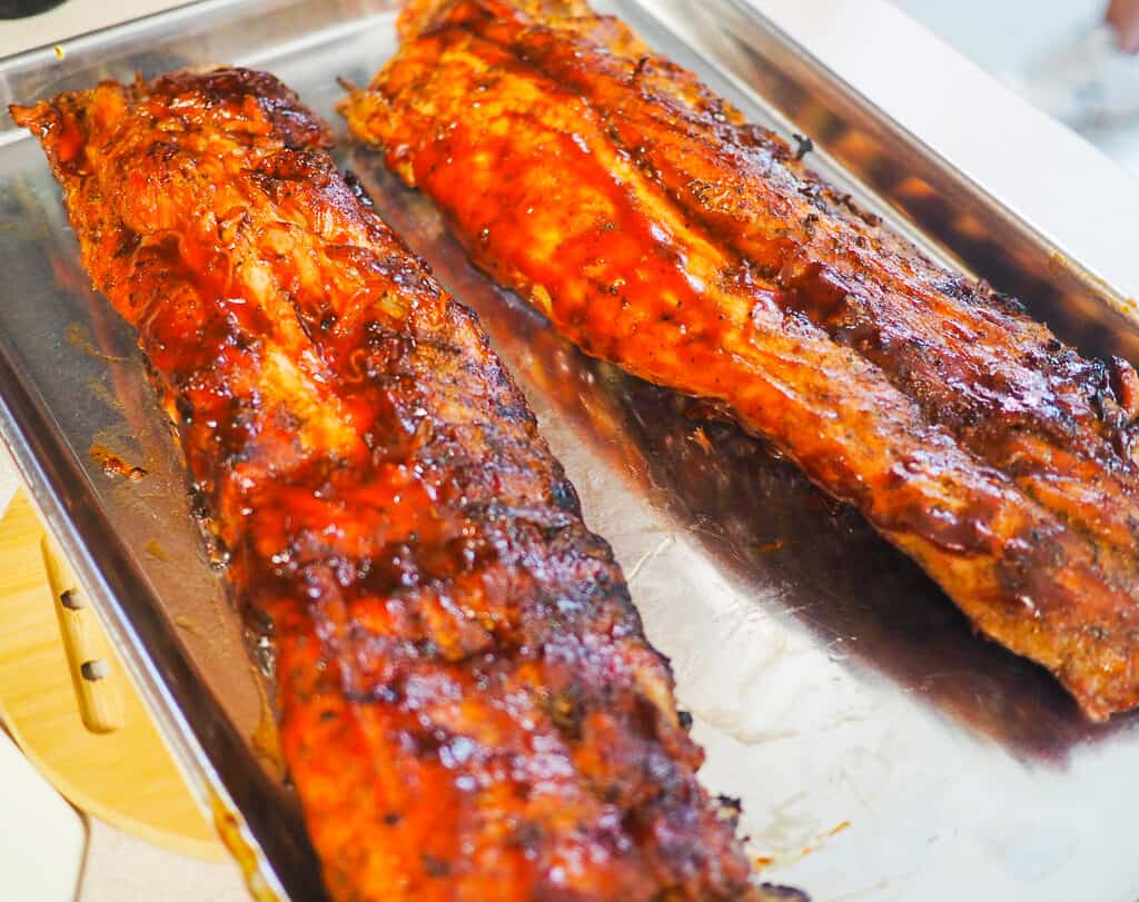 Grilled baby back ribs on a tray.
