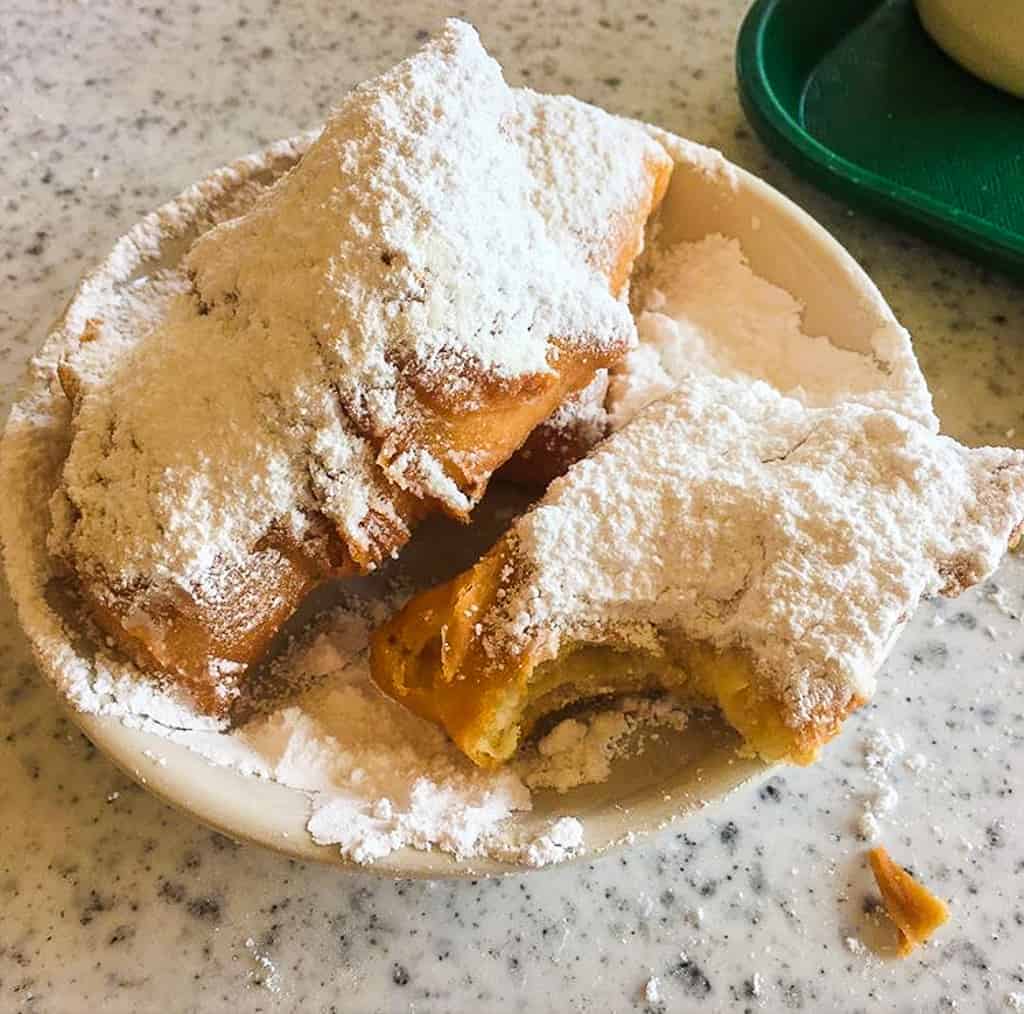 A plate of beignets covered in powdered sugar from Cafe du Monde in New Orleans.