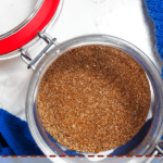 A pin image of a small jar with the mixed ingredients of Jamaican Jerk Seasoning and a blue dish cloth.