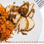 A pin image of a white plate with crispy sweet potato noodles and sliced Jamaican Jerk Chicken.