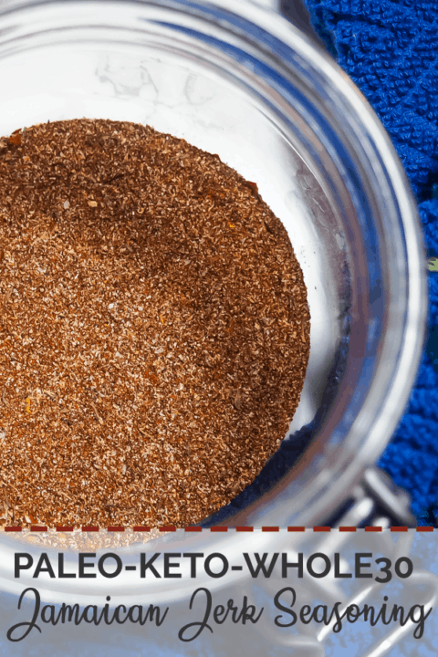 A pin image of a small jar with the mixed ingredients of Jamaican Jerk Seasoning (zoomed in) and a blue dish cloth.