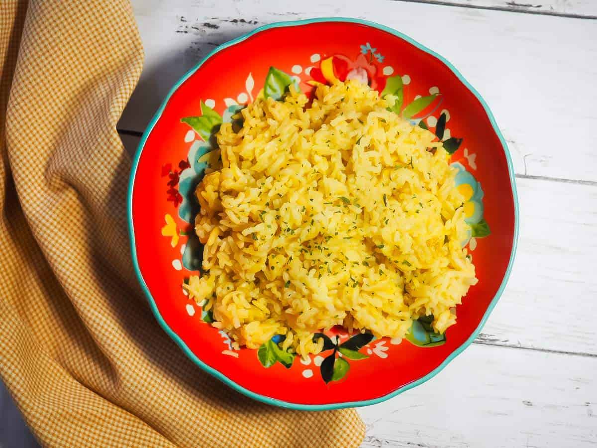 A red bowl filled with Instant Pot rice pilaf and a yellow napkin.