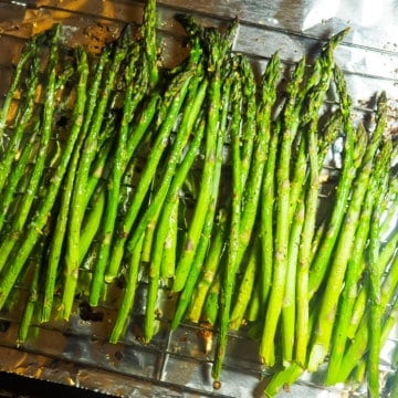 A sheet pan covered in foil with oven roasted asparagus.