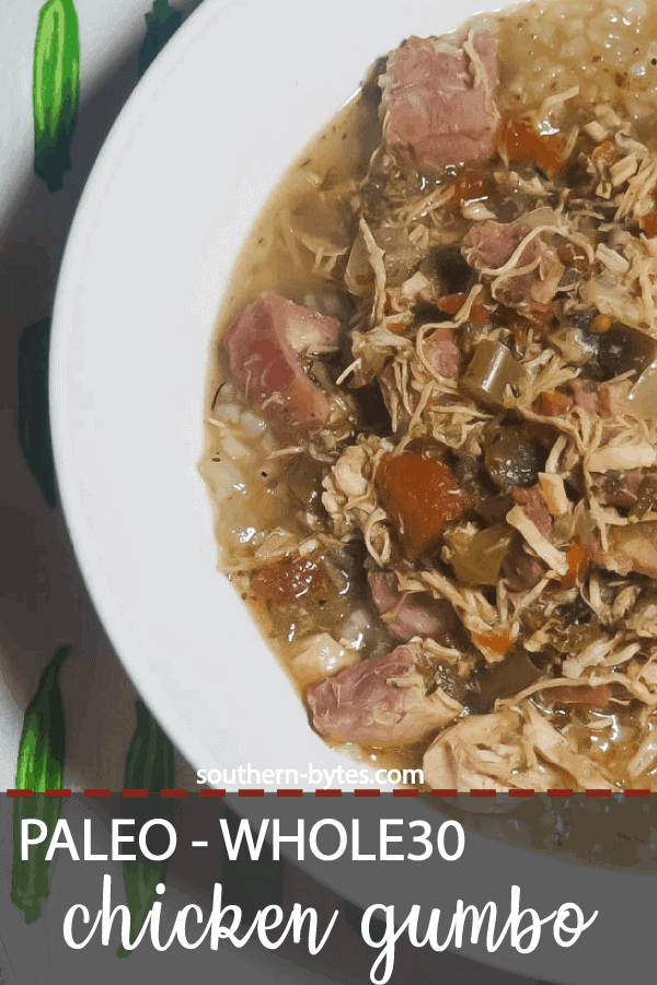 A pin image of a white bowl of paleo chicken and sausage gumbo on top of a tea towel covered in little okra.