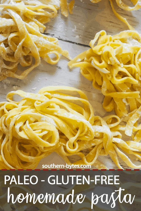 A pin image of piles of homemade paleo pasta on a white wooden board.