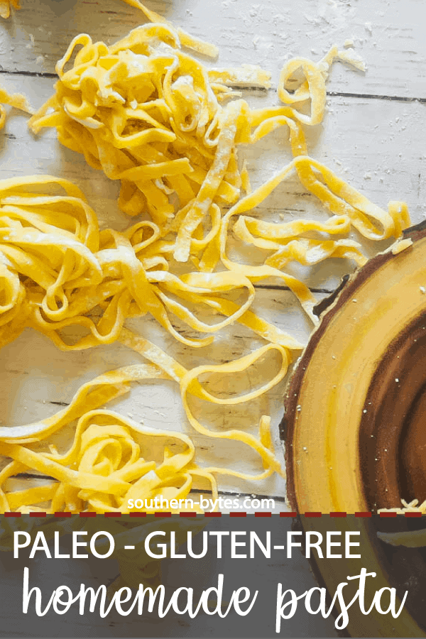 A pin image of piles of homemade paleo pasta on a white wooden board.