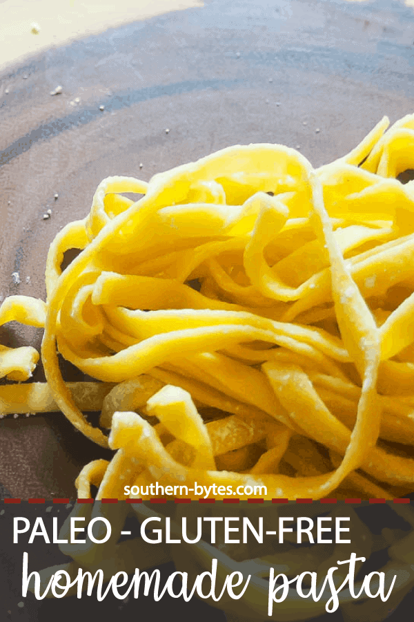 A pin image of a pile of paleo pasta cut into fettuccine on a wood cutting board.