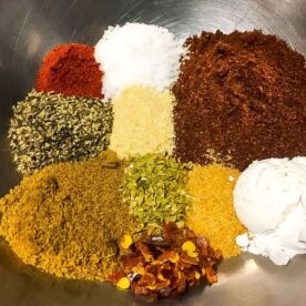 The ingredients in taco seasoning in a bowl, unmixed.