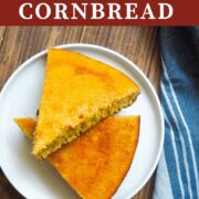 A white plate with slices of cornbread on it on a wooden background.