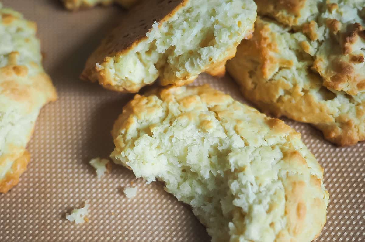 A zoomed in picture of drop biscuits on a non-stick baking mat.