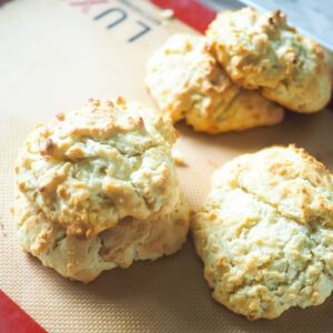 A pile of drop biscuits on a non-stick baking mat.