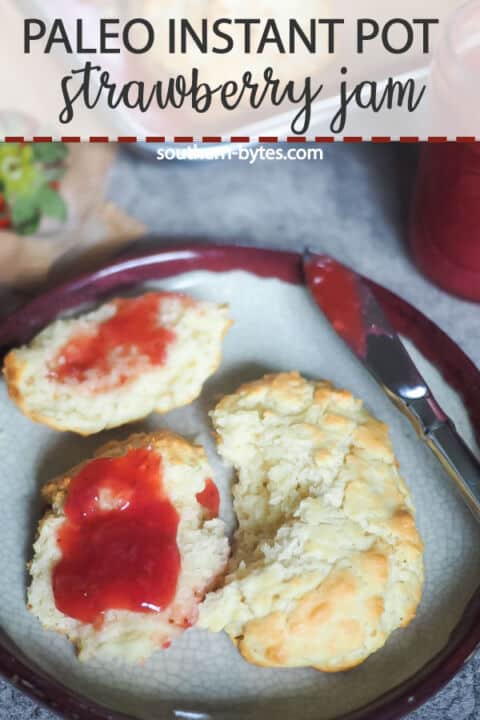 A pin image of some drop biscuits with paleo strawberry jam spread on them.