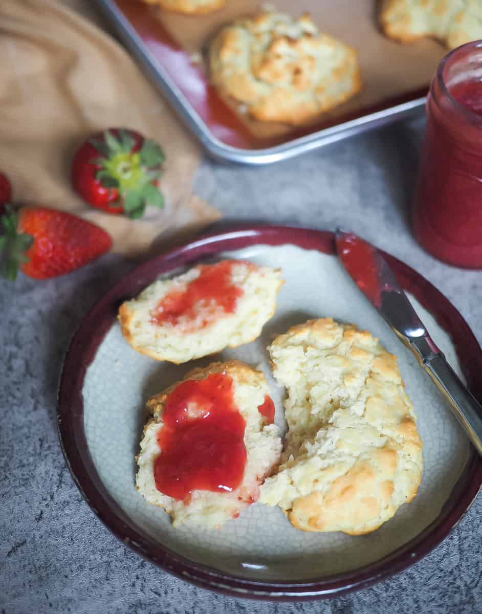 A picture of drop biscuits with paleo strawberry jam spread on them.