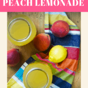A pin image of two jars of peach lemonade on a wood board with peaches, a lemon, and a colorful placemat.