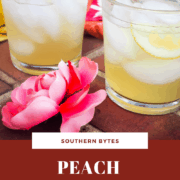 A pin image of two glasses of peach lemonade with a pink flower on brick stairs.