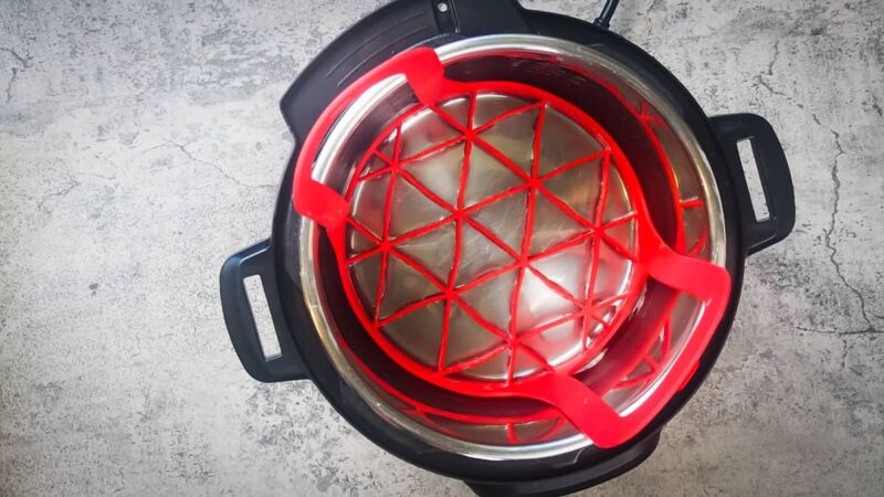 an instant pot with a red sling in it