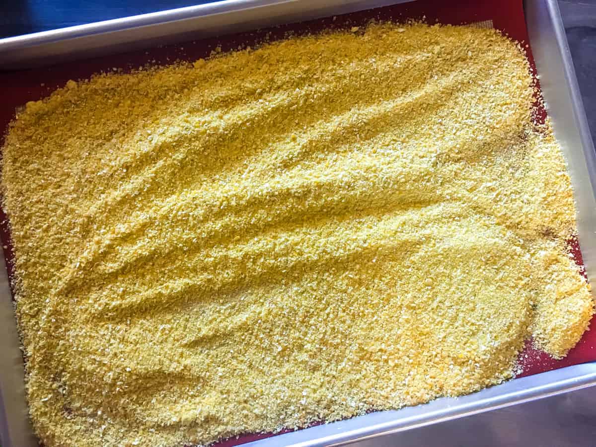 a baking sheet with homemade cornmeal spread on it