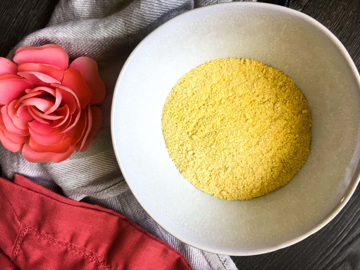 a white bowl of homemade cornmeal with a pink flower