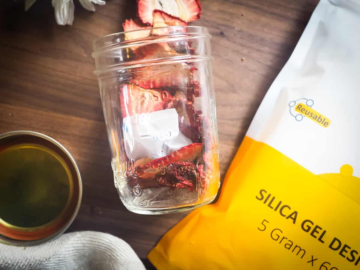 a spilled jar of dehydrated strawberries with a bag of desiccant packs