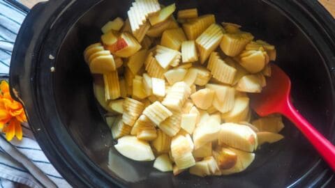 a crockpot with sliced apples in it.
