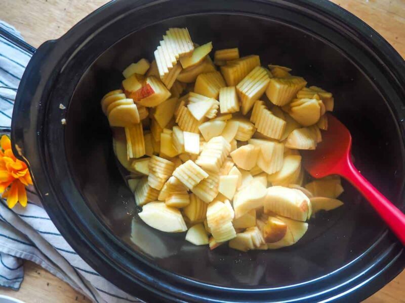 a crockpot with sliced apples in it.