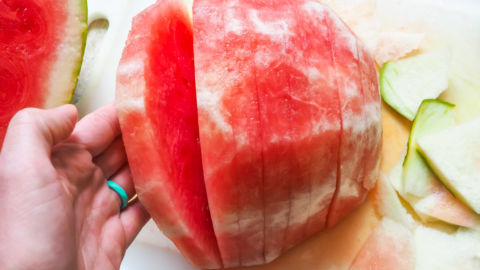 Thick slices of watermelon on a white cutting board.
