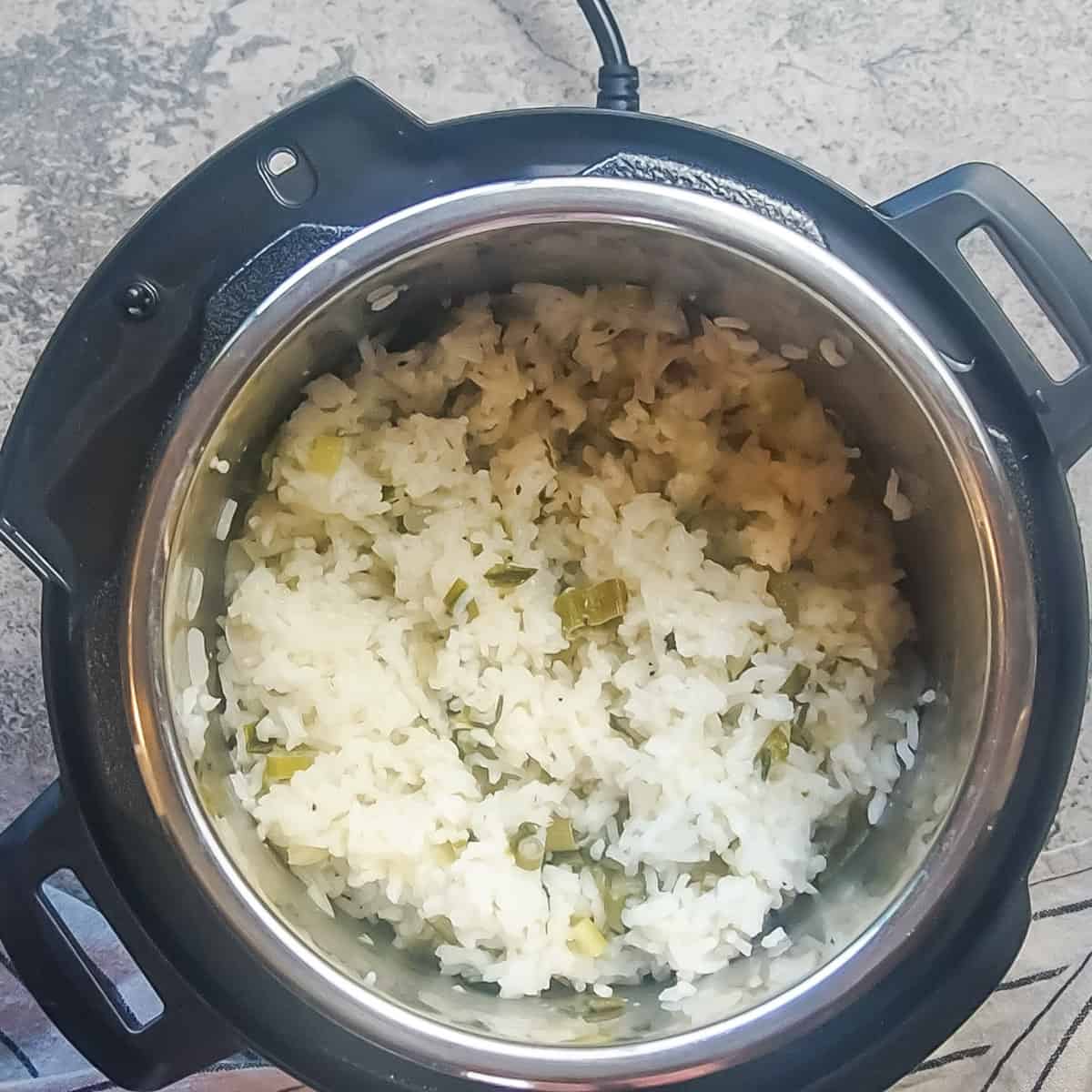 an instant pot with green onion rice in it