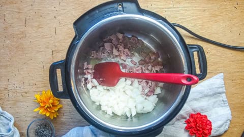 bacon and onions cooking in an instant pot.
