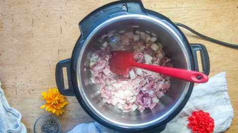 ham, bacon, and onions cooking in an instant pot.