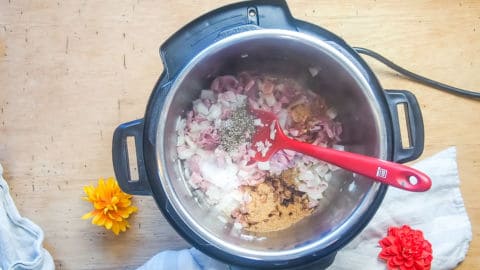 ham, bacon, and onions with spices in an instant pot.