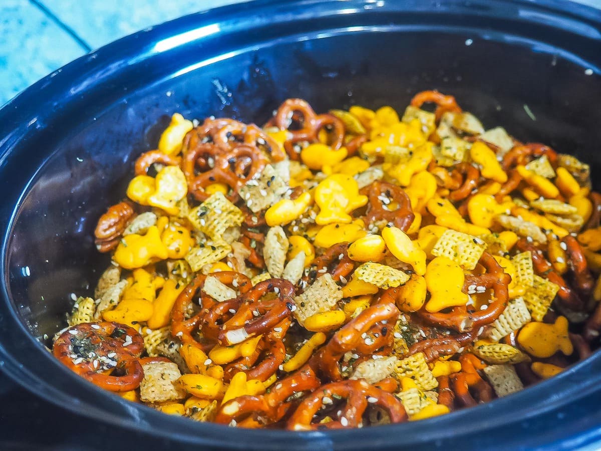 A crock pot with chex party mix in it.