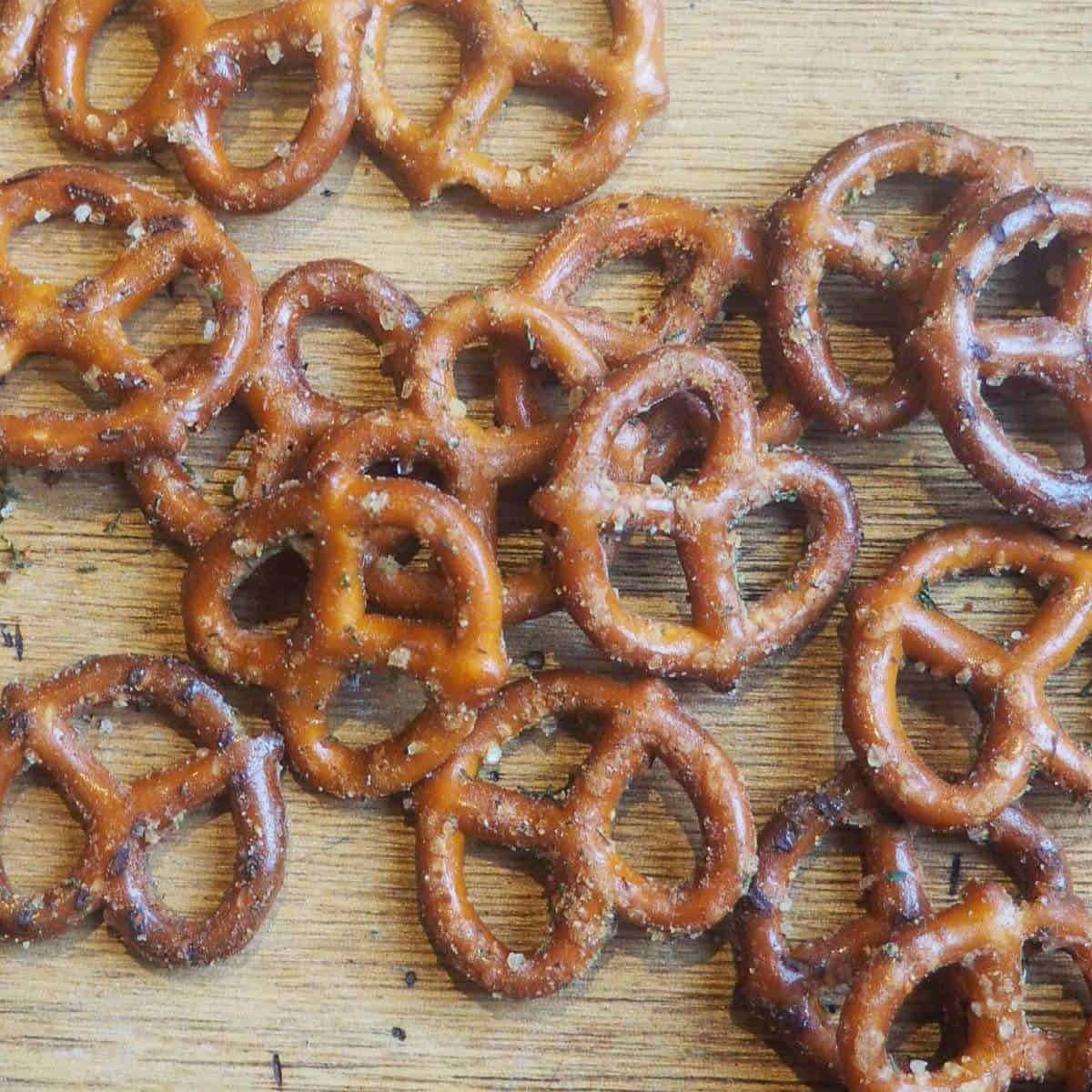 Seasoned pretzels spread out on a wooden board.