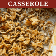 A pin image of green bean casserole covered in crispy onions in a baking dish.