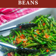 A pin image of a serving dish filled with ginger green beans and a pair of tongs.