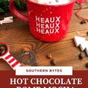 A pin image of a red mug of mocha hot cocoa with garland behind it.