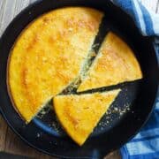 A cast iron skillet with slices of cornbread in it.
