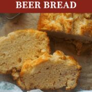 A pin image two slices of beer bread on parchment next to the rest of the loaf.
