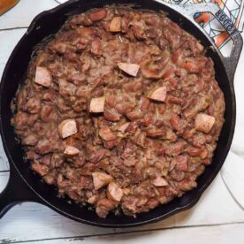 Homemade red beans with sausage in a cast iron skillet with a New Orleans dish towel