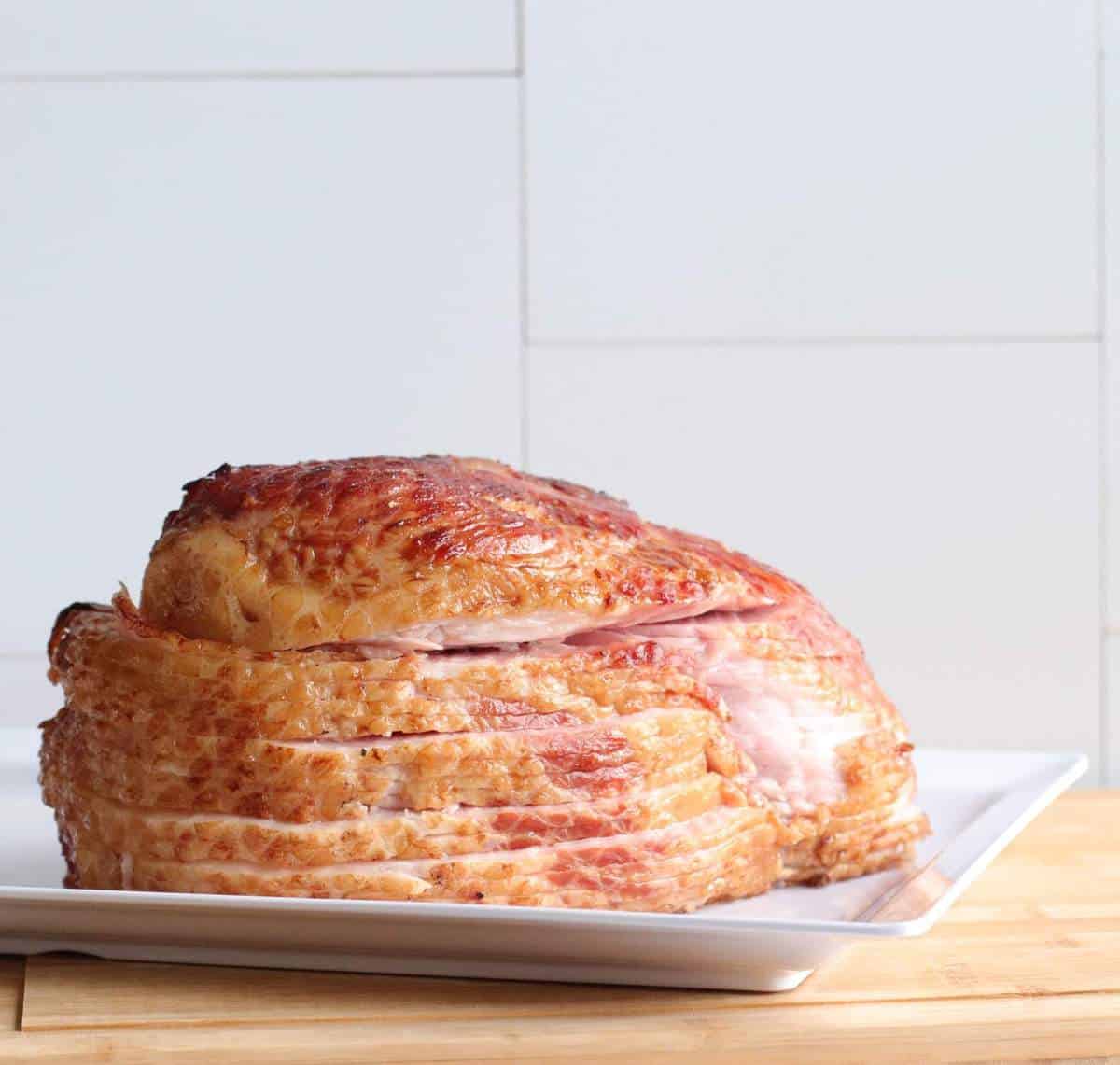 A sliced ham on a white plate.
