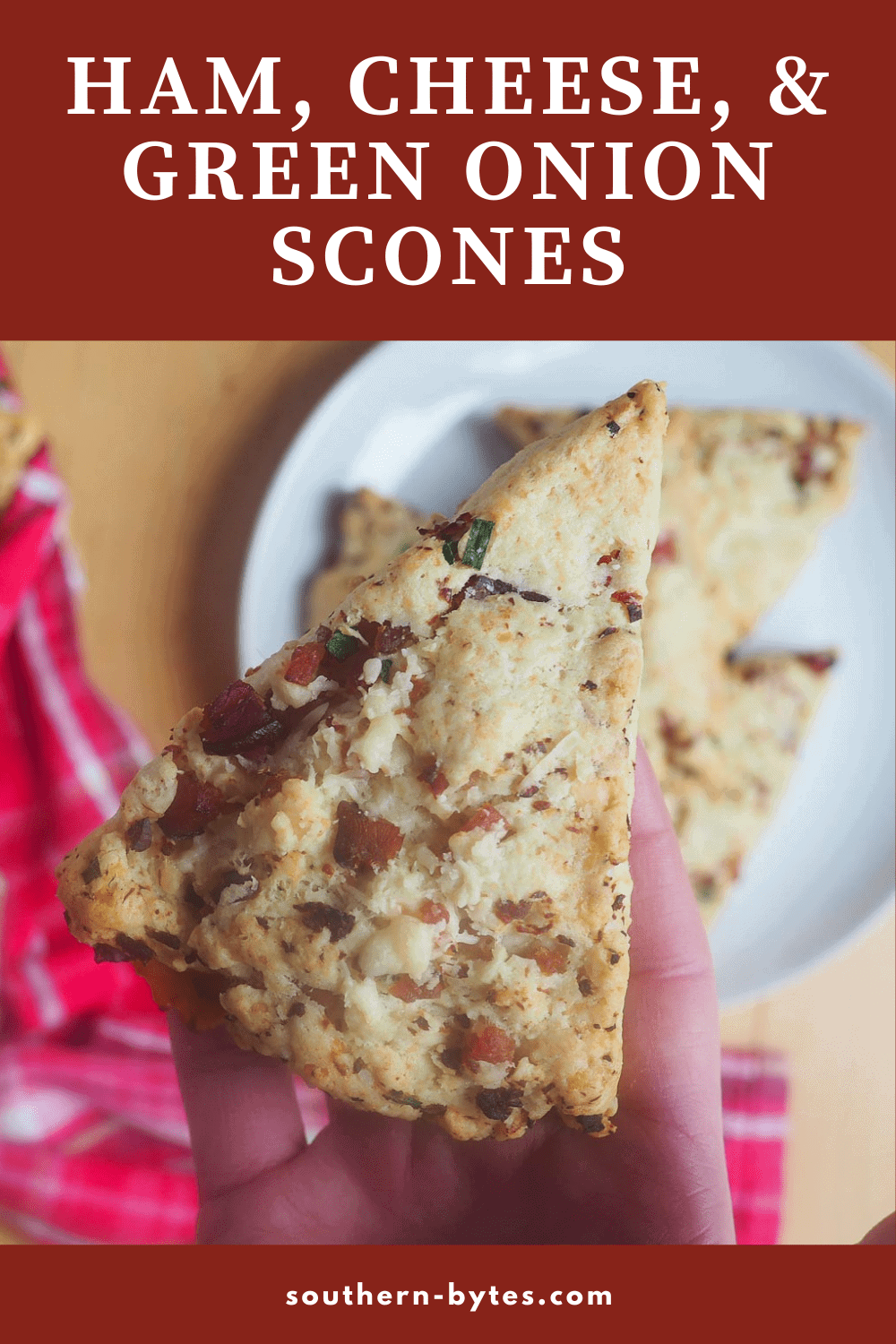 A pin image of a hand holding a ham and cheese scone.