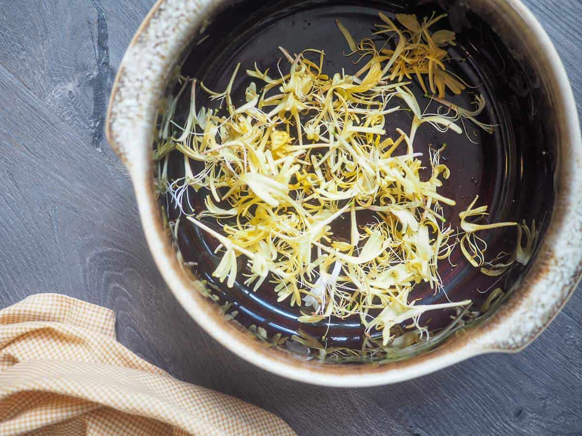 A brown bowl of honeysuckle blossoms.