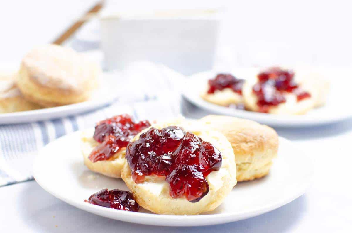 A plate of biscuits with jelly on them.
