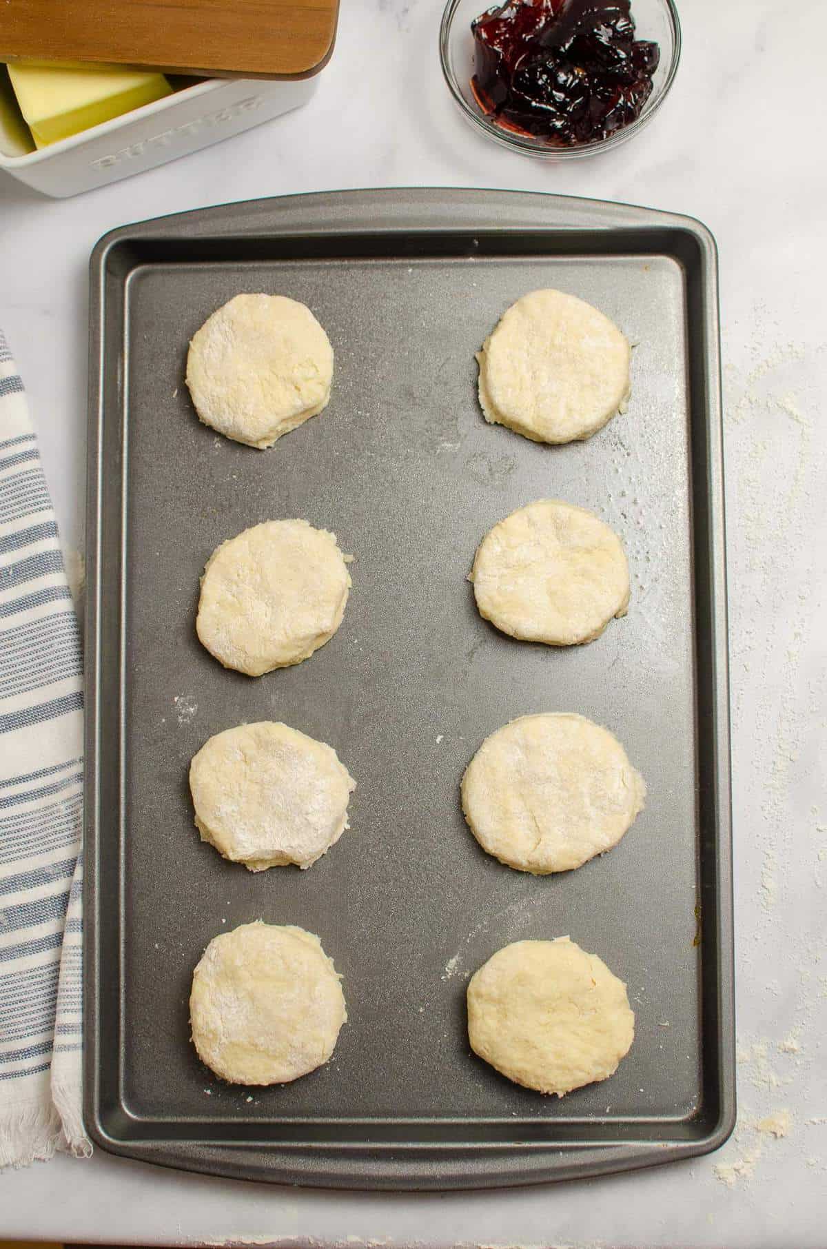 8 unbaked sour cream biscuits on a baking sheet.