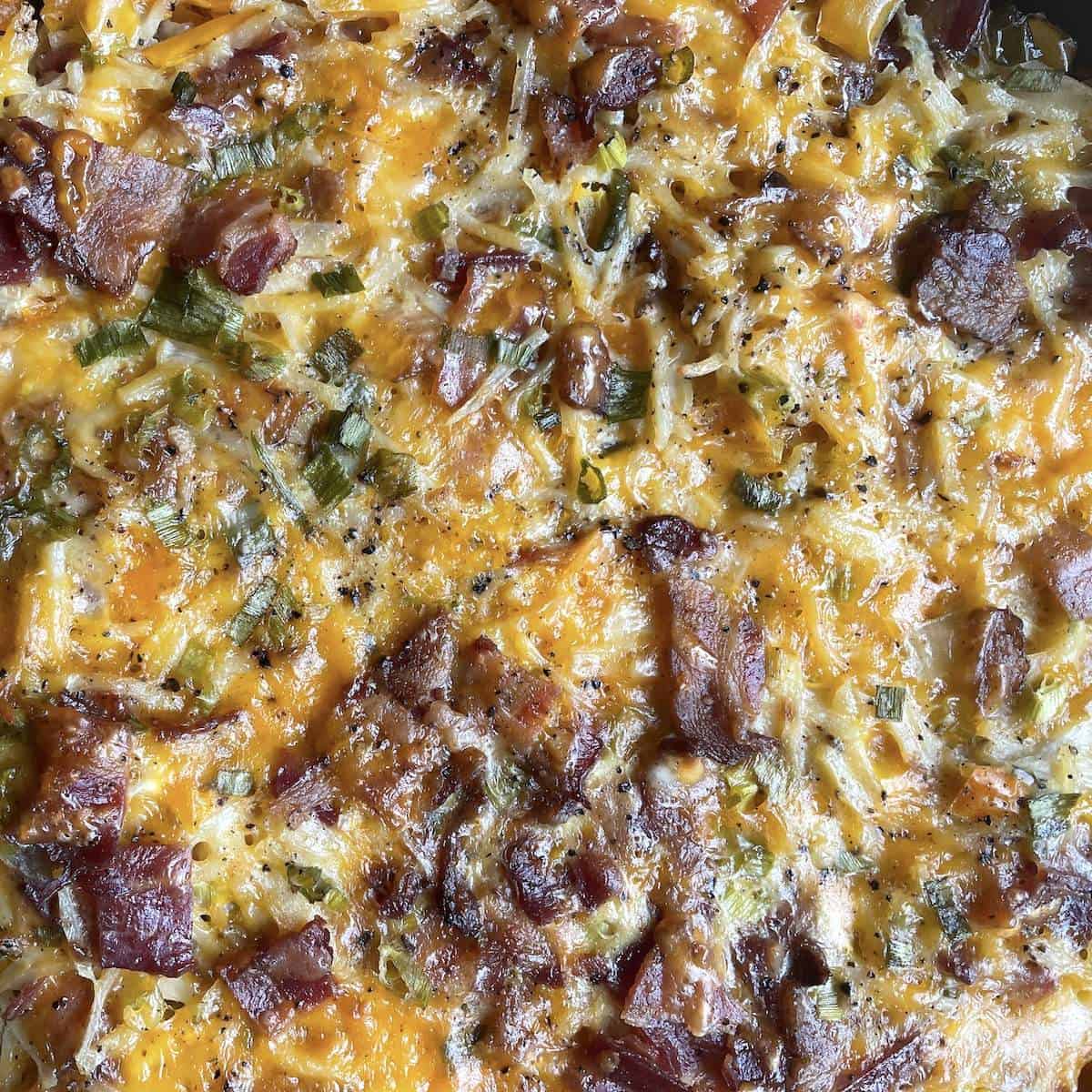 A zoomed in image of hash brown casserole with bacon.
