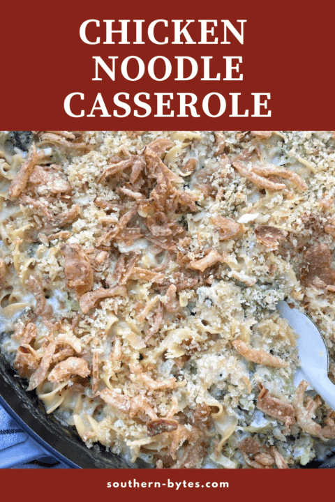 A pin image of a large cast iron pan filled with cheesy chicken and broccoli noodle casserole with a white serving spoon with overlay text.